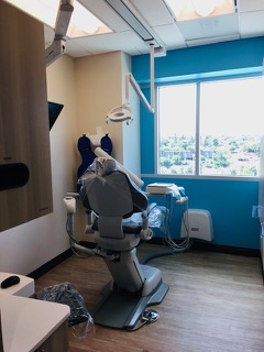 The image shows an interior space with medical equipment, including a dental chair, and a room with medical instruments and a window view.