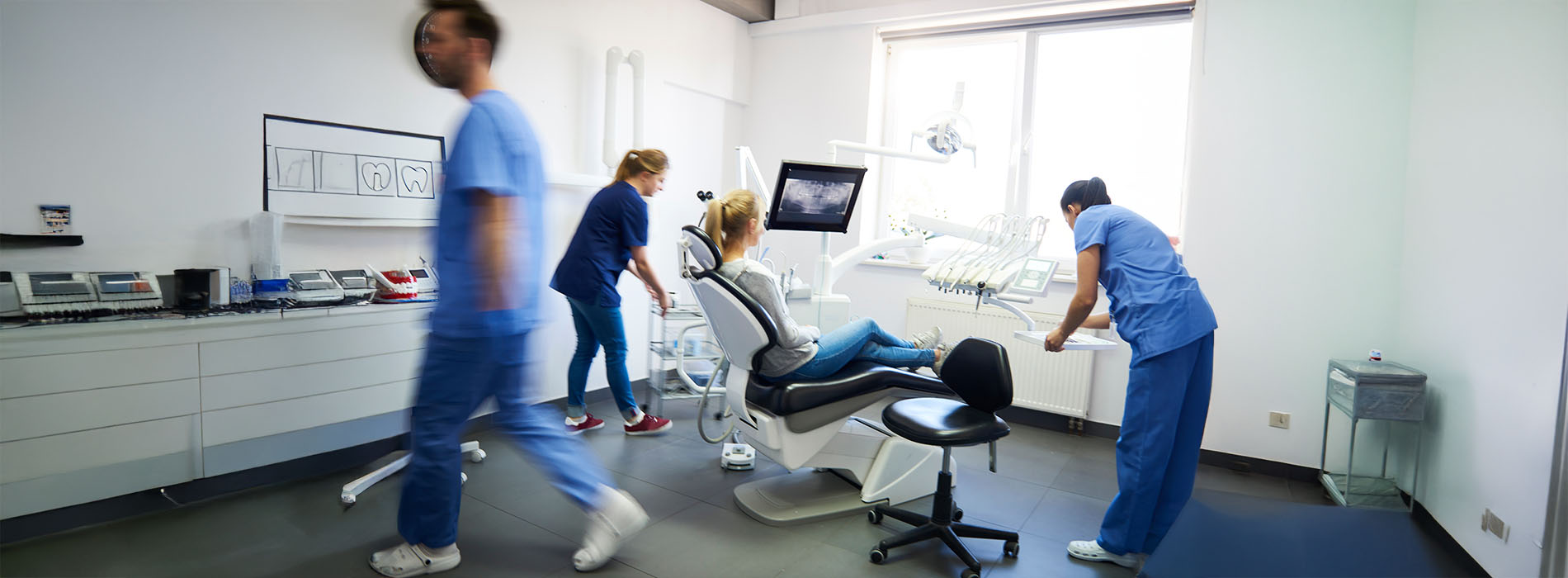 The image depicts a collage of four photos showing a woman walking through an office space with medical equipment and furniture, accompanied by a man in scrubs who appears to be assisting her.