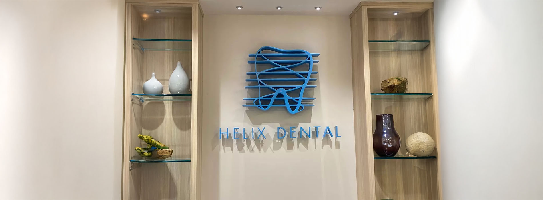 The image shows an interior space with a display case containing various objects, including vases and decorative items. Behind the display case, there is a sign with text and logos, indicating that this is likely a dental office named  The Dental Spa.