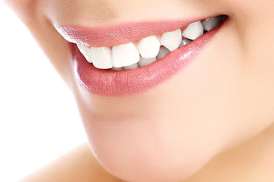 The image shows a close-up view of a person s face with a focus on their teeth, which are being highlighted by a smile.