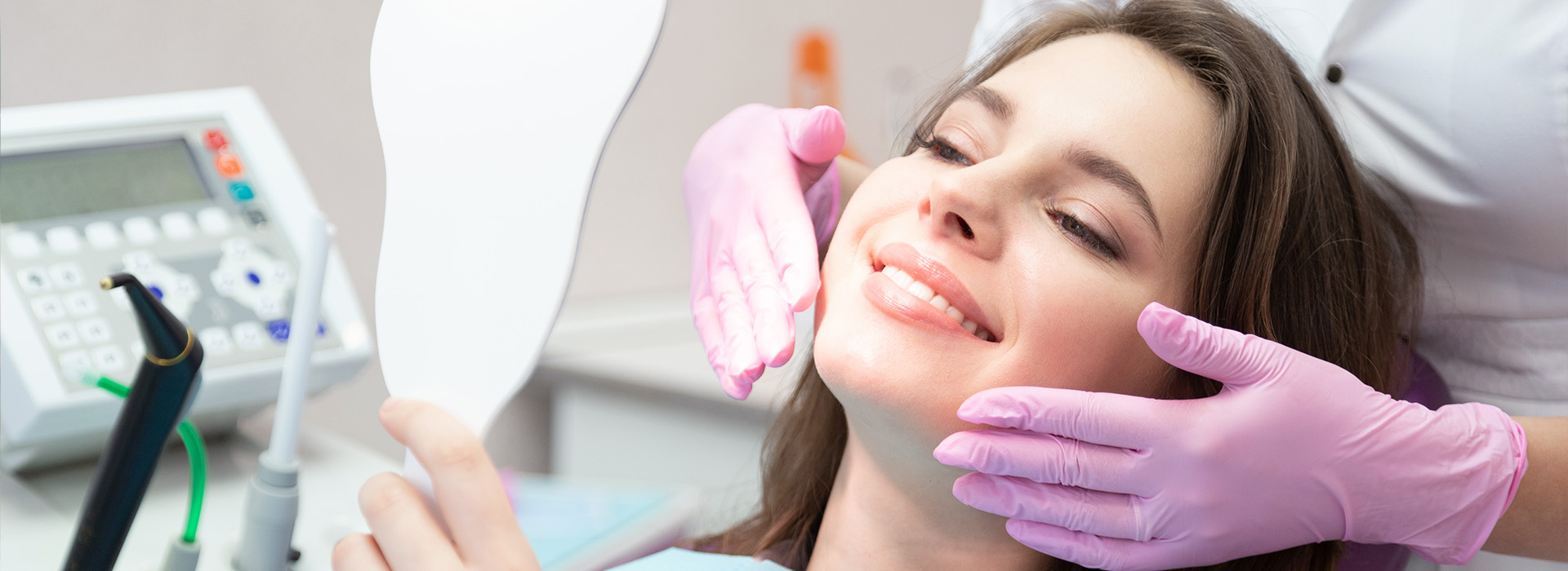 The image shows a person sitting in a dental chair with their mouth open, receiving dental care from a professional wearing a face mask and gloves.