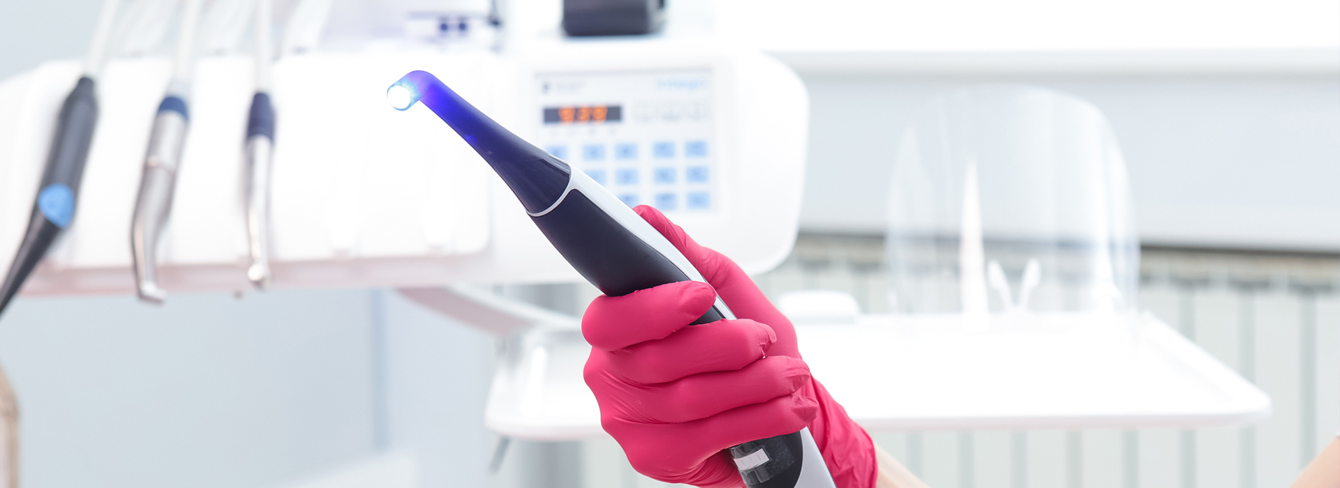 Woman holding a flashlight with pink gloves on.