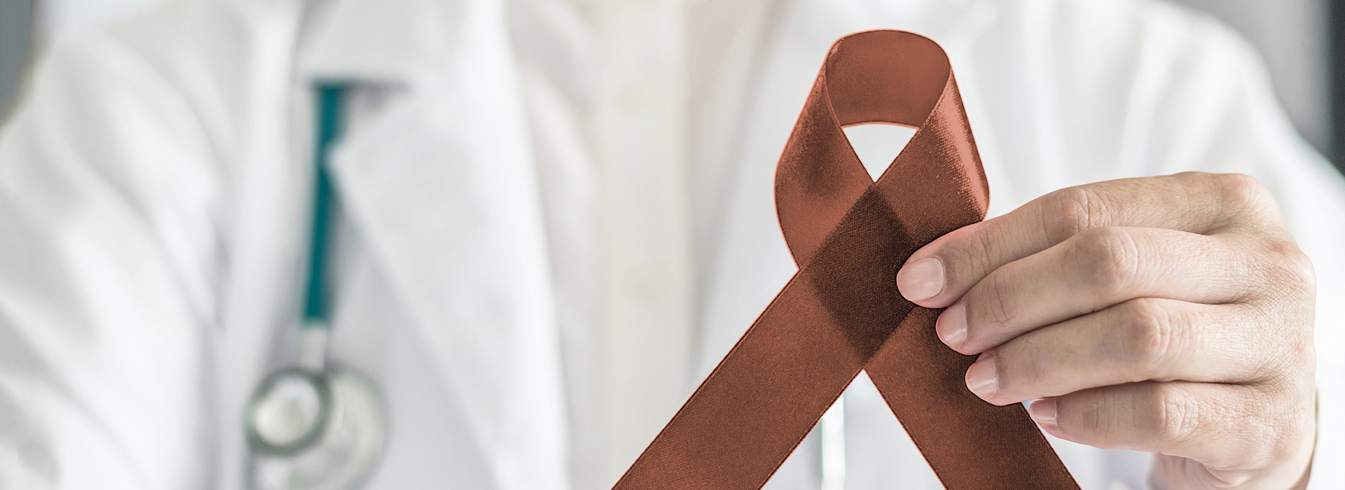 The image shows a person holding a brown ribbon with a white cross symbolizing medical aid, standing behind a doctor who appears to be wearing a stethoscope and is holding a red ribbon, which is often associated with awareness for certain health conditions.