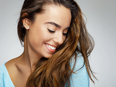 A woman with long brown hair smiles at the camera.